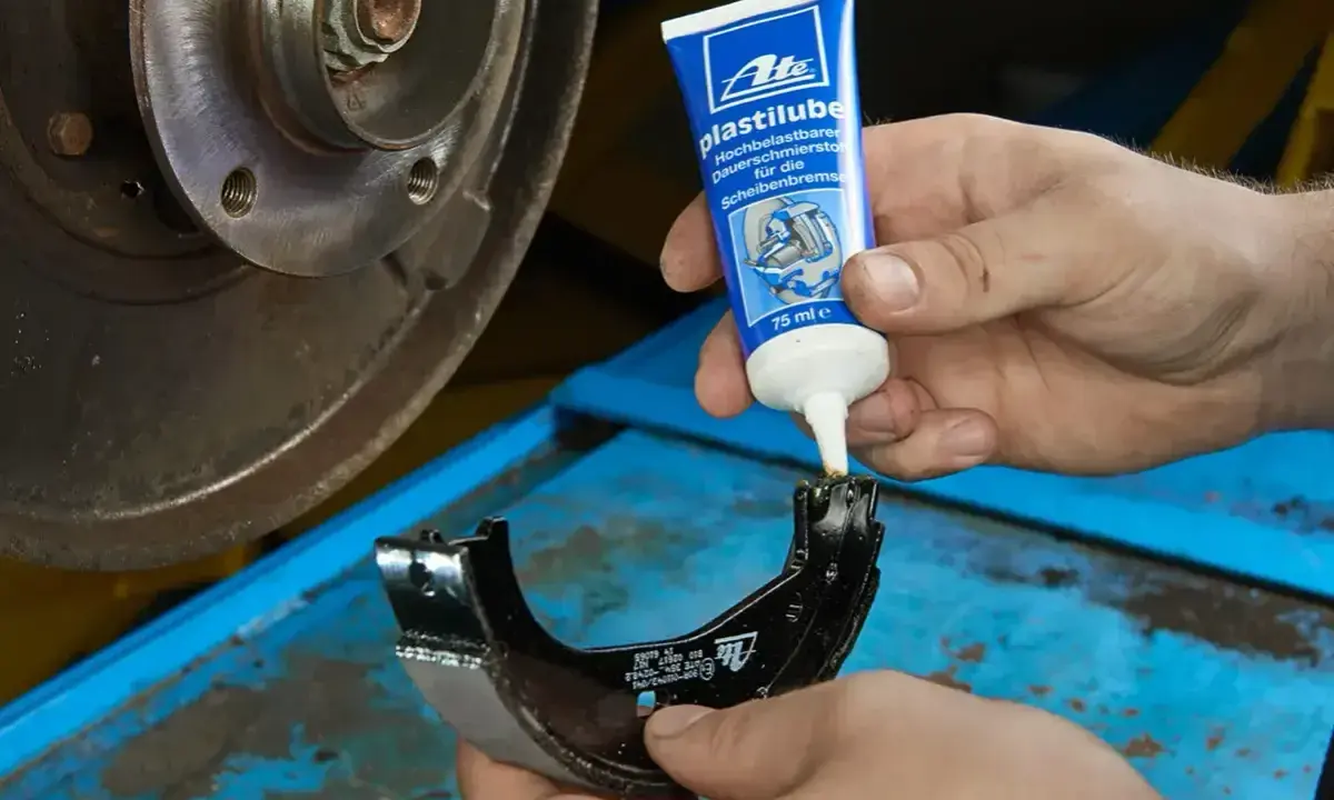 Mechanik aplikuje smar ATE Plastilube na prowadnice zacisku hamulcowego. To kluczowe, by wiedzieć, jaki smar do prowadnic hamulcowych wybrać.