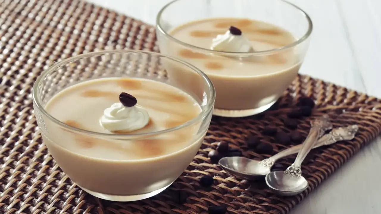 Deux verrines de crème au café façon Danette, garnies de chantilly et d'un grain de café.