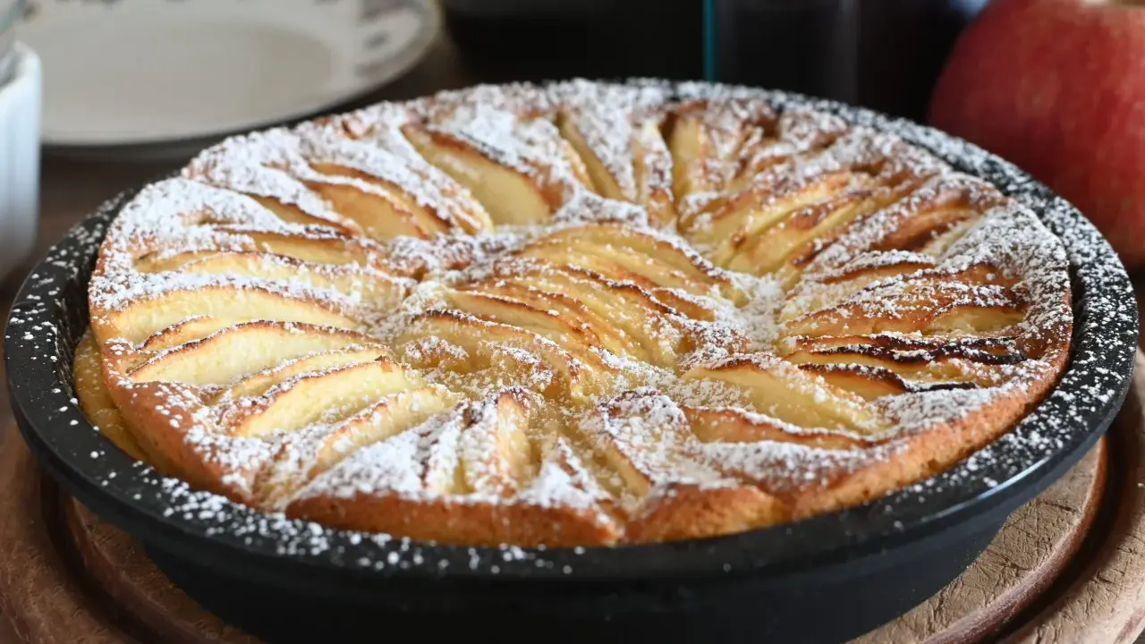 Torta di mele in friggitrice ad aria, dorata e cosparsa di zucchero a velo, pronta per essere gustata.
