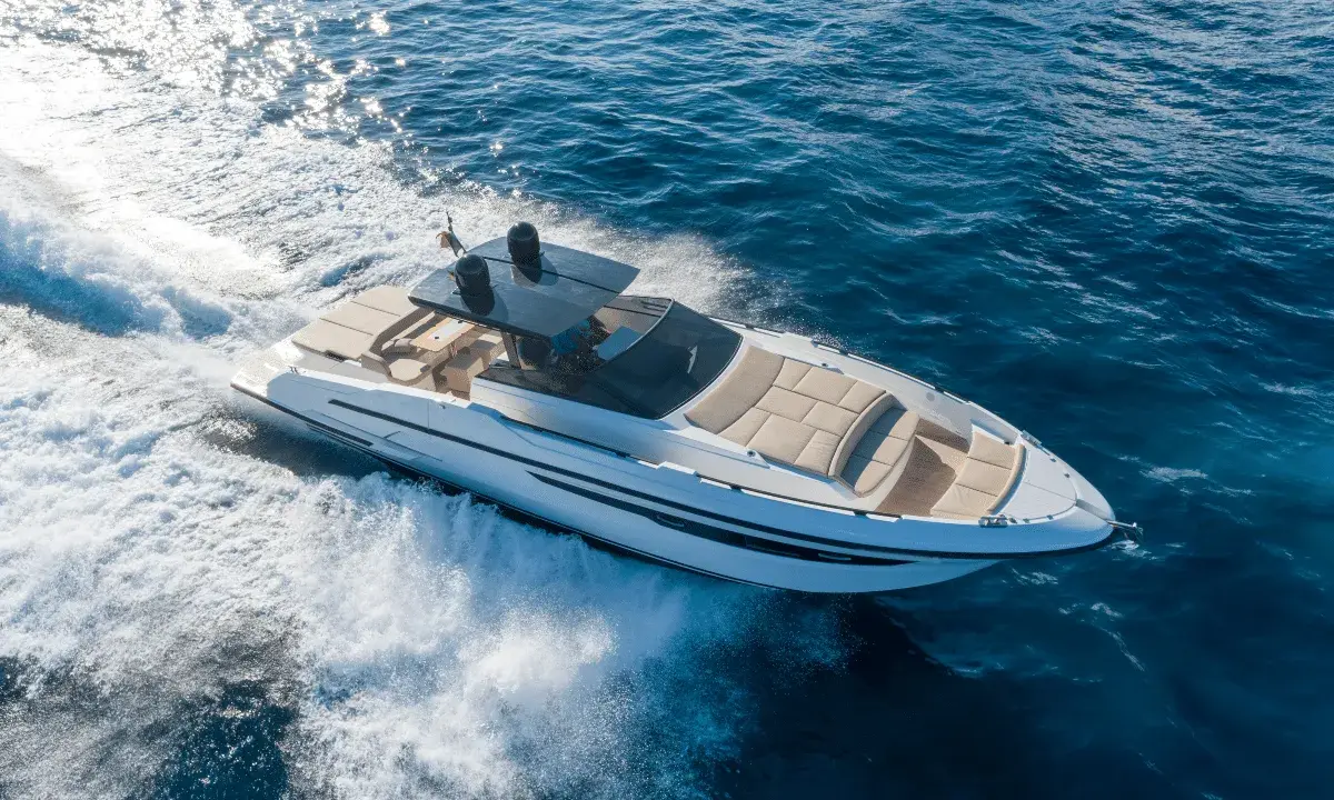 Yacht blanc filant sur l'eau bleue, créant une écume blanche. Idéal pour surveiller son bateau à distance.