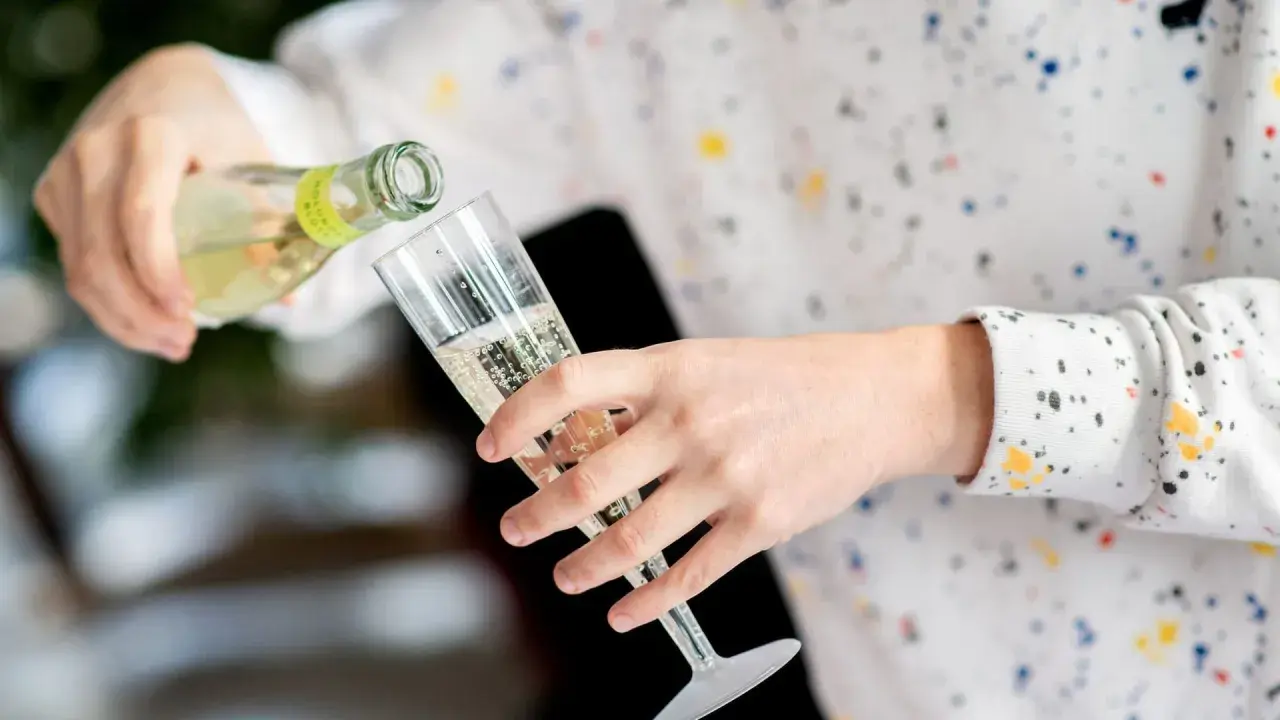 Sekt wird in ein Glas gegossen. Die Frage, wie lange ist Sekt haltbar, beschäftigt viele Genießer.
