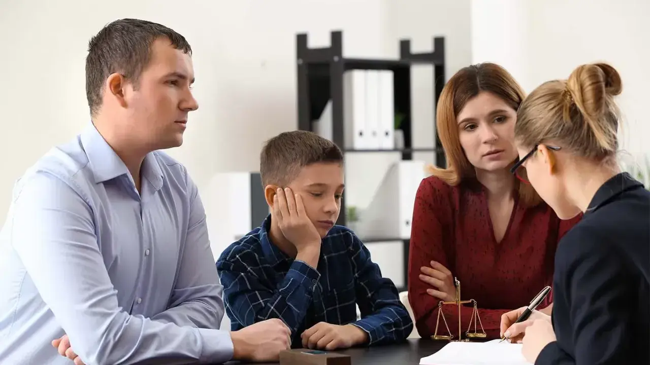 Rodzina z dzieckiem rozmawia z prawniczką o tym, ile trwa nadzór kuratora nad nieletnim.
