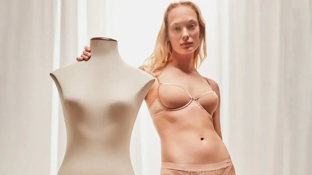 Modella con lingerie color carne, taglia italiana 85D, accanto a un manichino.