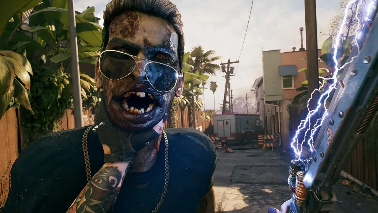Zombiak w okularach przeciwsłonecznych, z otwartymi ustami, trzymający broń zasilaną elektrycznością. To wygląda na fragment rozgrywki z gry Dead Island 2.