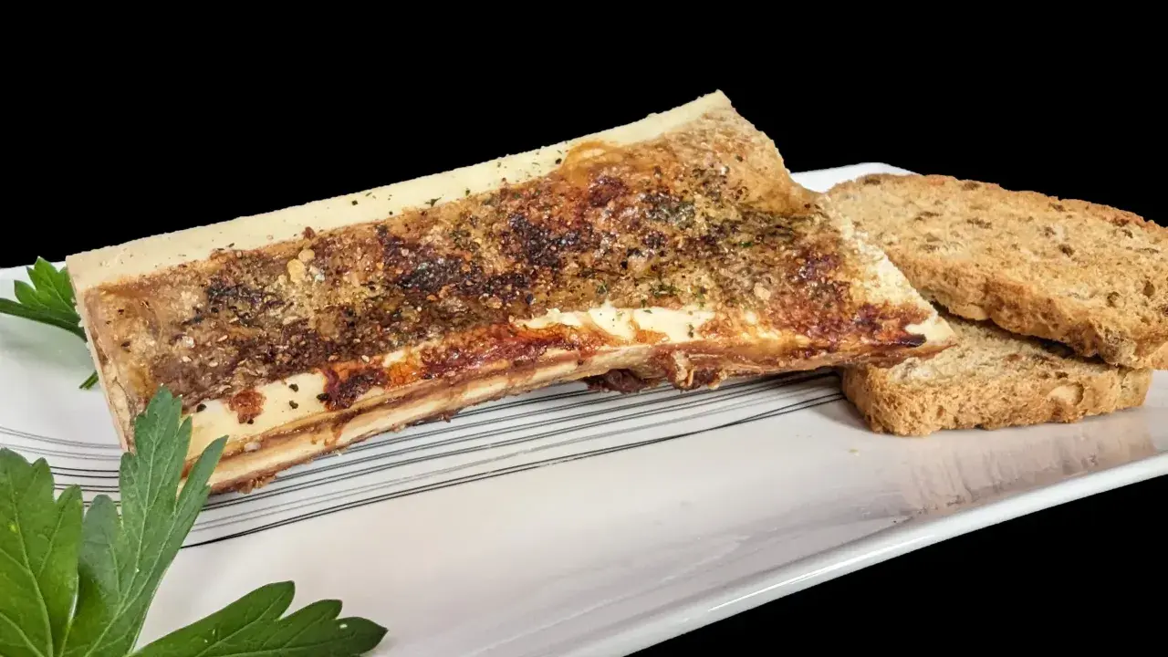 Os à moelle rôti, assaisonné d'herbes et de poivre, servi avec des toasts croustillants. Une recette os à moelle gastronomique à savourer.