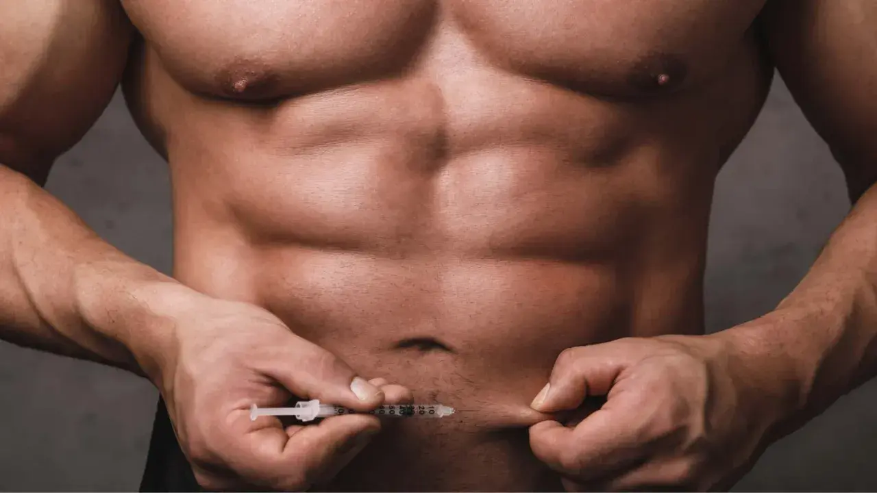 Ein Mann mit starker Muskulatur injiziert sich etwas in den Bauch. Dies könnte mit dem Thema Muskelaufbau Hormone zusammenhängen.