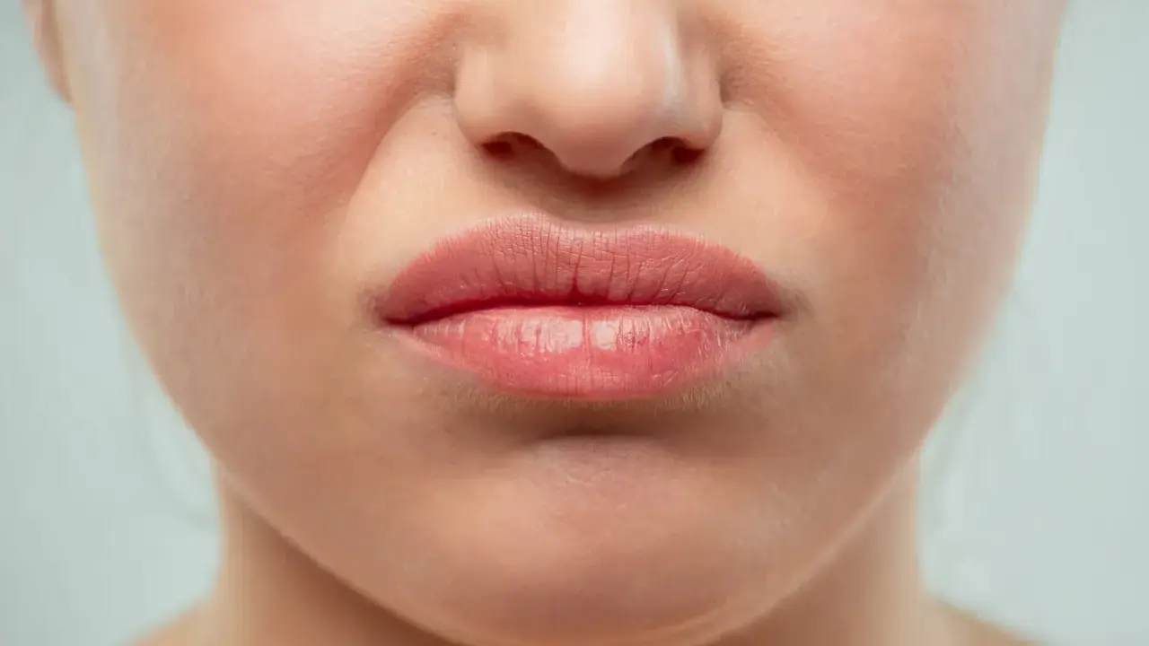 Gros plan sur une bouche pincée, le nez rouge que faire ? Une expression de dégoût ou de gêne.