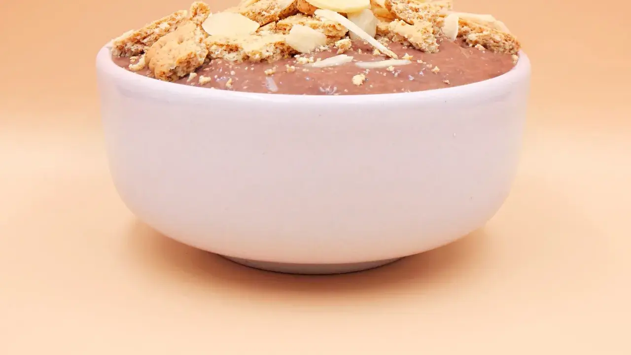 Czekoladowy pudding proteinowy z płatkami migdałów i pokruszonymi ciasteczkami. Czy pudding proteinowy jest zdrowy? To zależy od składników!