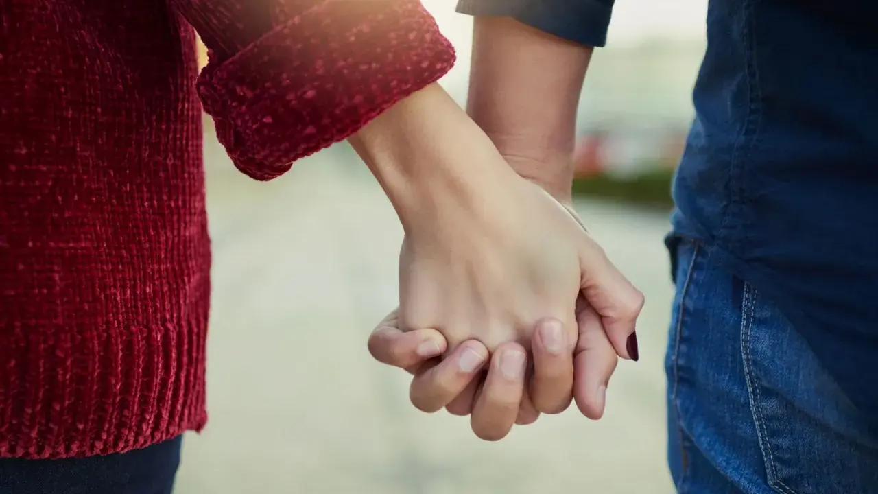 Mani che si stringono, simbolo del significato dell'ancora in amore: stabilità, sicurezza e un legame profondo che resiste alle tempeste.