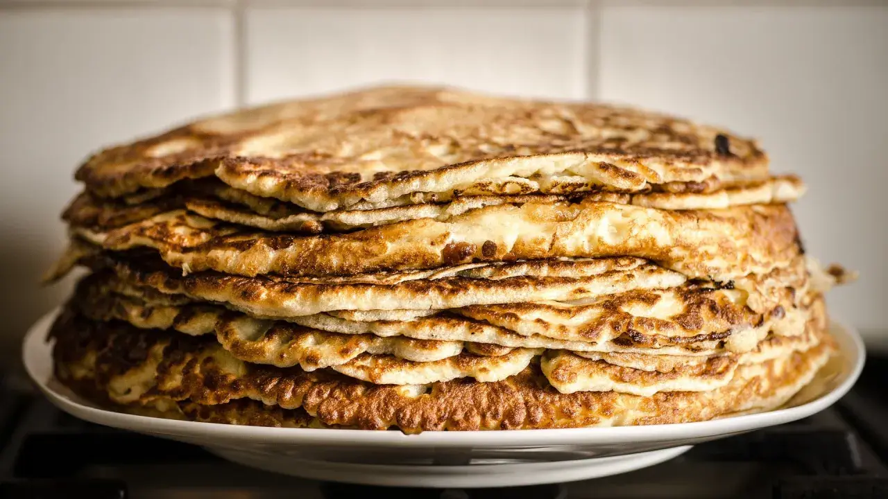 Pile généreuse de crêpes à la farine de châtaigne, dorées et appétissantes, prêtes à être dégustées.