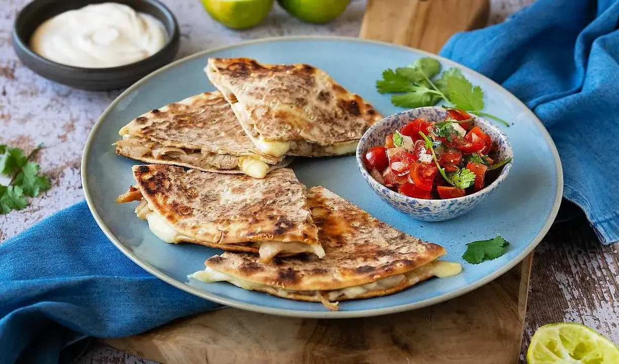 Här är ett läckert quesadillas recept! Krispiga quesadillas med smält ost, serverade med salsa, gräddfil och lime.