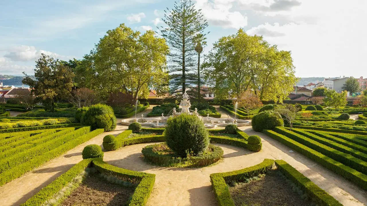 Ein barocker Garten mit Brunnen und akkurat geschnittenen Hecken vor dem Ajuda-Palast in Lissabon.