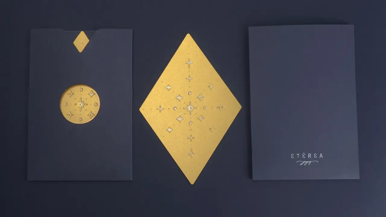 Elegantes ideas para postales navideñas: sobre azul con detalles dorados de estrellas y un rombo central.