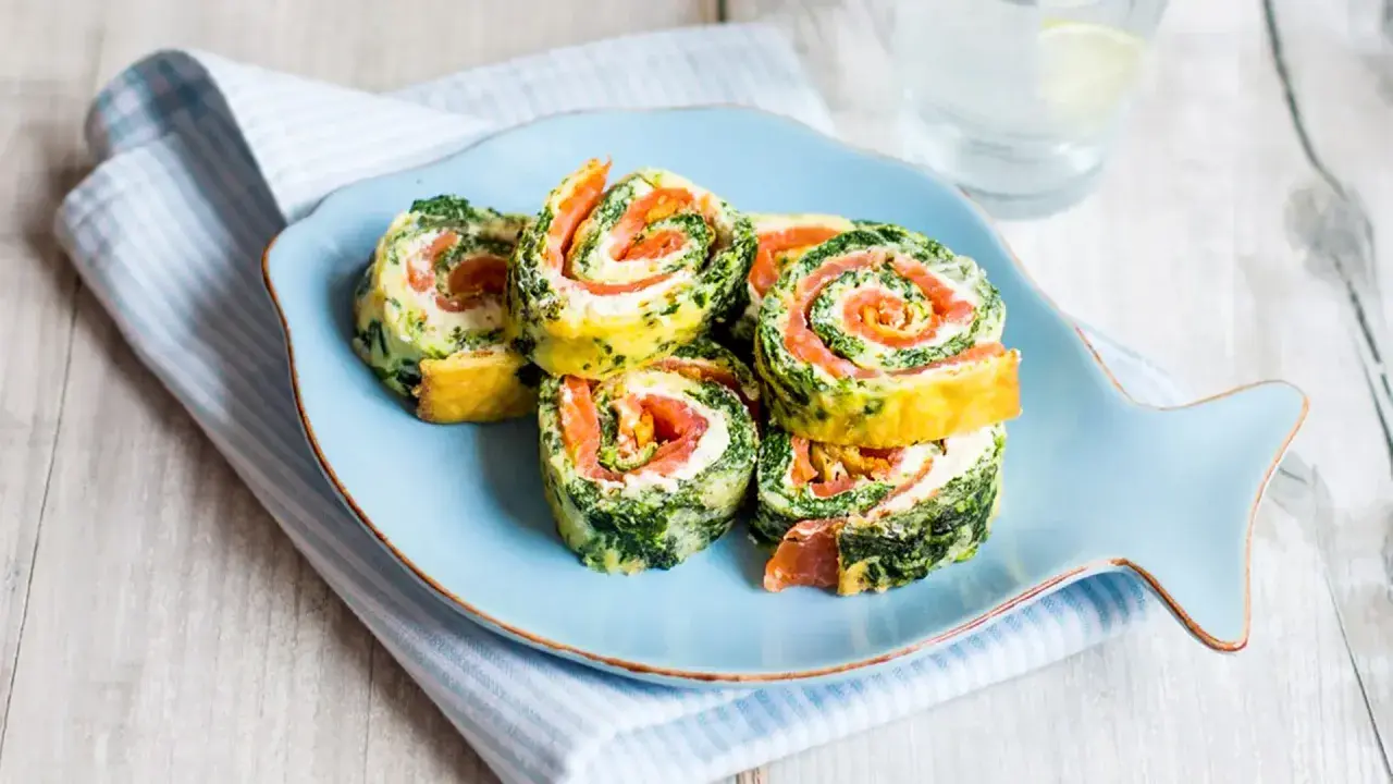 Rouladen mit Lachs und Spinat auf einem Fisch-Teller. Leckere Morbus Crohn Rezepte, die gut verträglich sind.