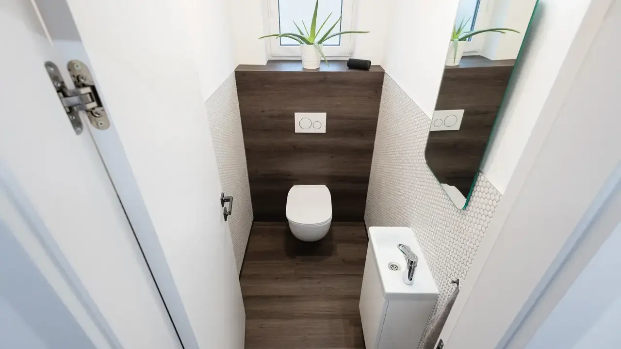 Bagno piccolo moderno con sanitari sospesi, lavandino compatto e specchio asimmetrico. Ottime idee bagno piccolo per sfruttare ogni centimetro.