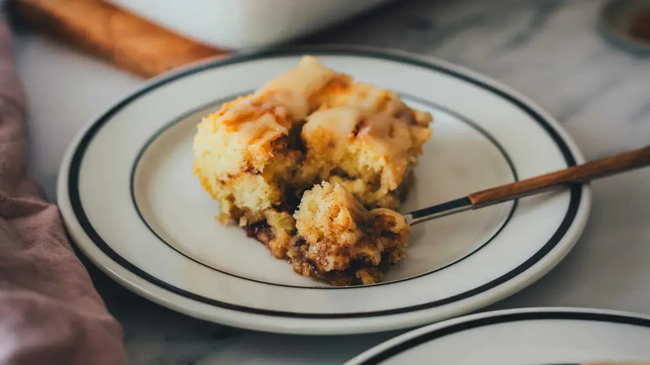 Ein Stück saftiger Zimtschneckenkuchen mit Zuckerguss, perfekt für ein Zimtschneckenkuchen Rezept.