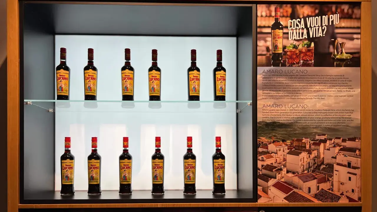 Butelki amaro Lucano stoją na półkach, tworząc elegancką ekspozycję.