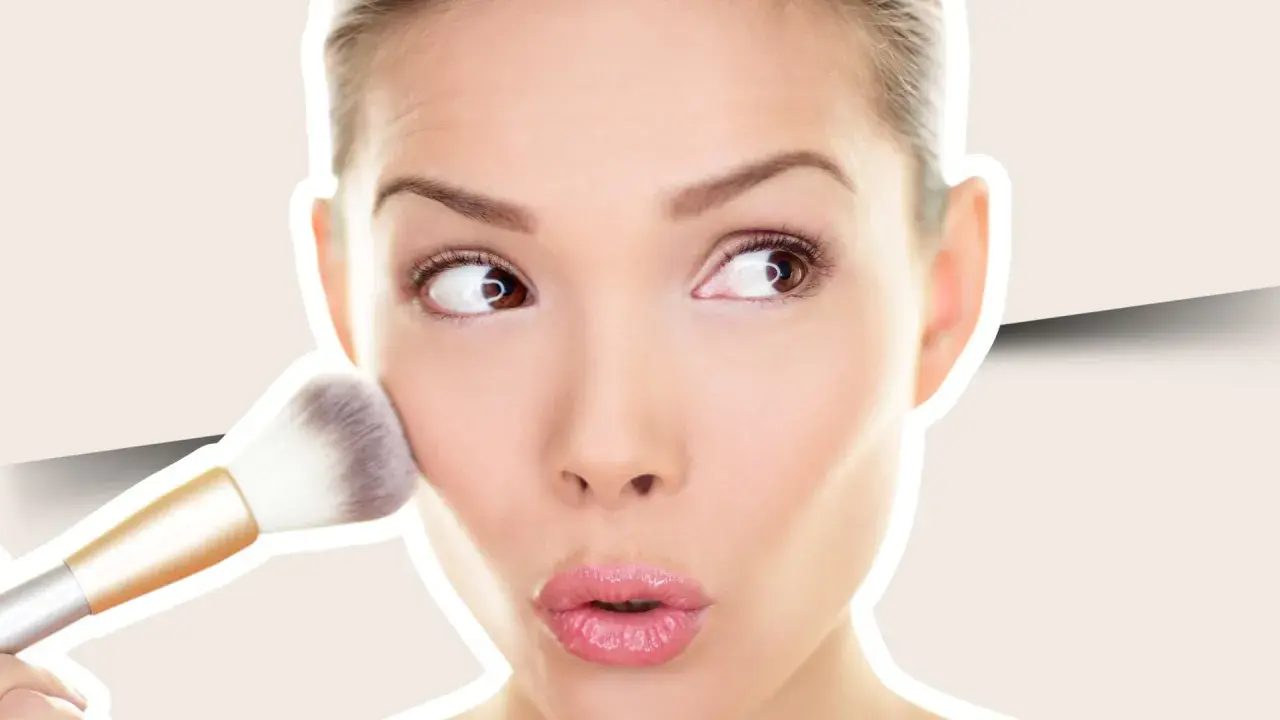 Una mujer aplica colorete en crema en sus mejillas con una brocha, creando un look natural y radiante.