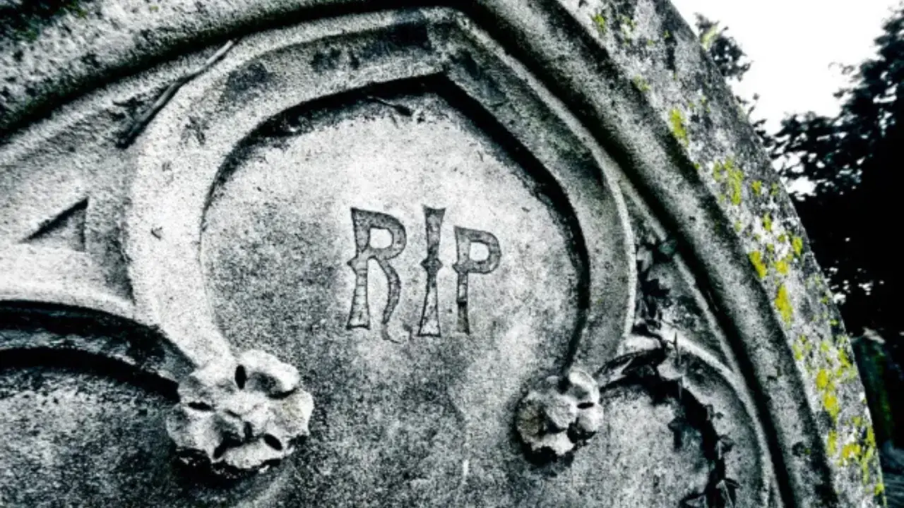 Napis "RIP" na kamiennym pomniku, co oznacza "Requiescat in pace" (Niech spoczywa w pokoju), symbolizuje wieczny odpoczynek.