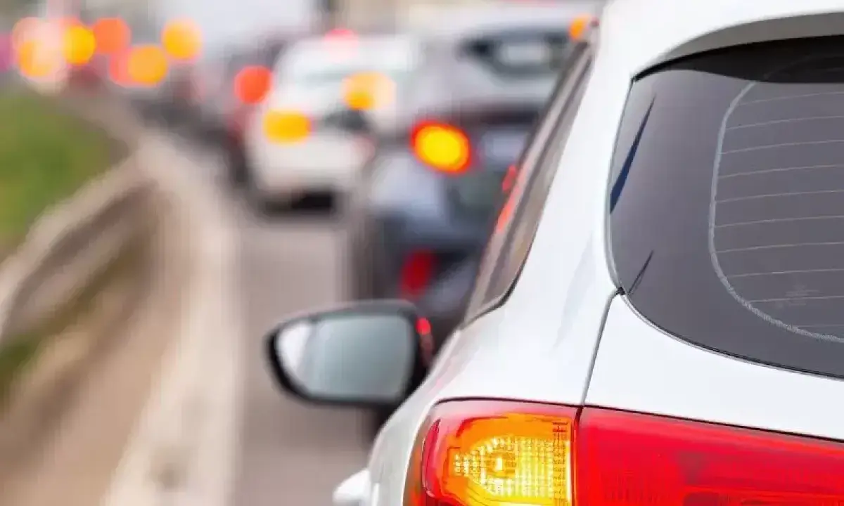 Un coche blanco en un atasco, con sus luces de freno rojas encendidas. ¿Cuántas luces de freno tiene un coche?