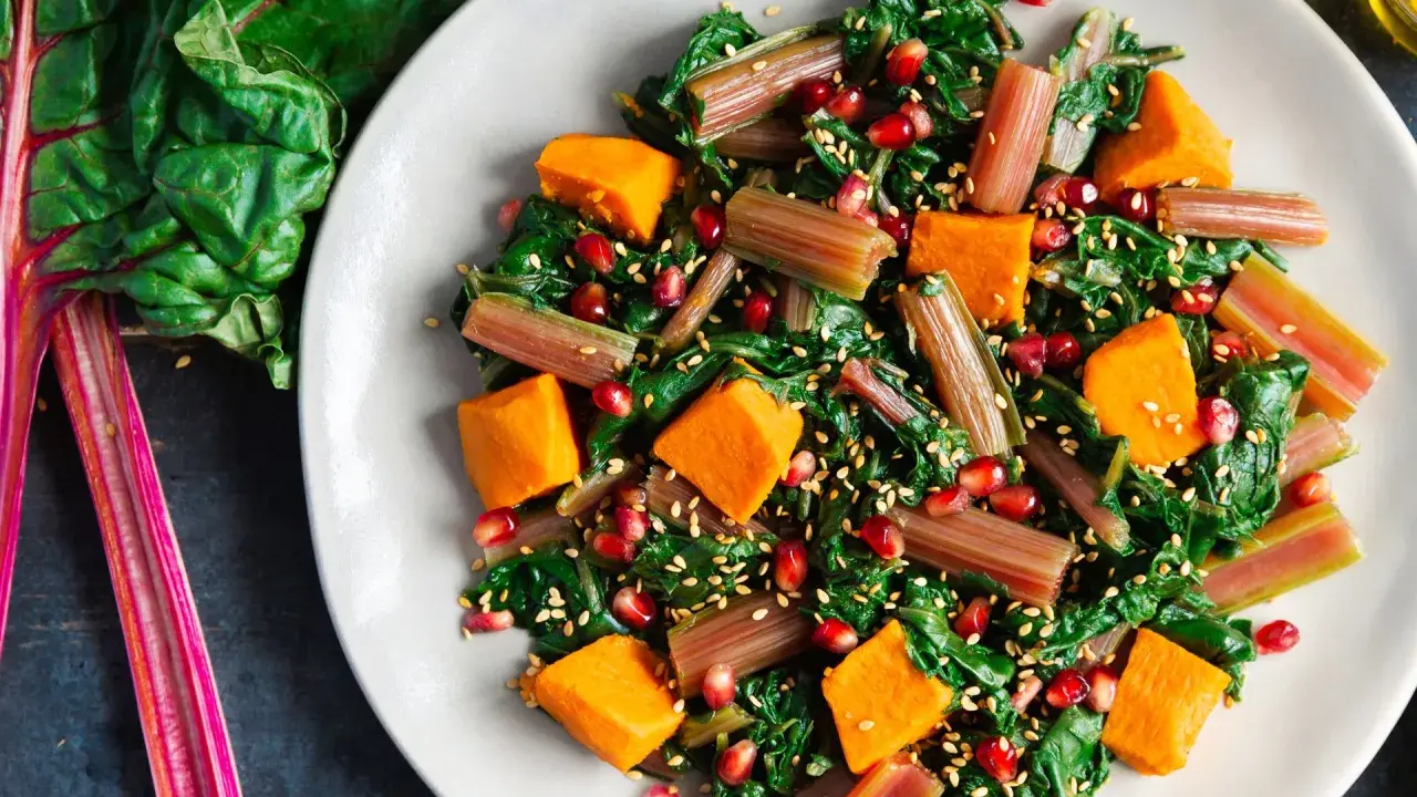 Ensalada vibrante con acelgas, calabaza, granada y semillas de sésamo. Una de las muchas recetas con acelgas que te encantarán.