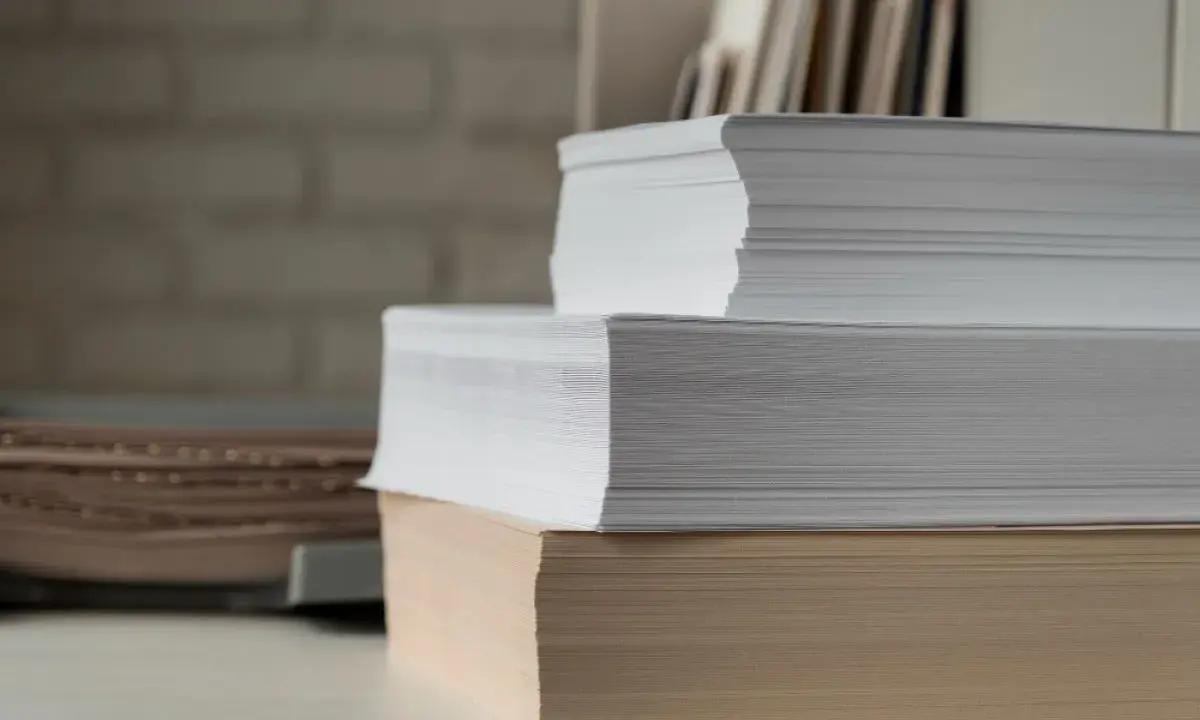 Stosy białego i beżowego papieru, gotowe do druku. Ten papier powlekany czeka na kreatywne projekty.