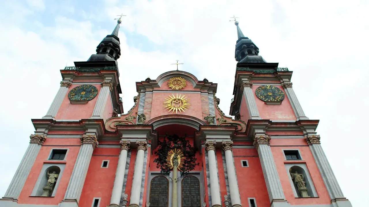 Święta Lipka: barokowa bazylika z zegarami na wieżach i złotymi symbolami religijnymi. Atrakcje tego miejsca przyciągają turystów.