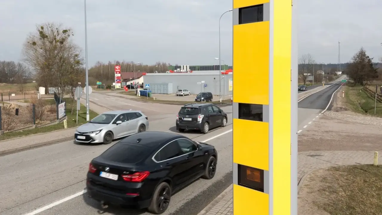 Żółty fotoradar przy drodze, monitorujący ruch samochodów. Tak działa system, który rejestruje prędkość pojazdów.