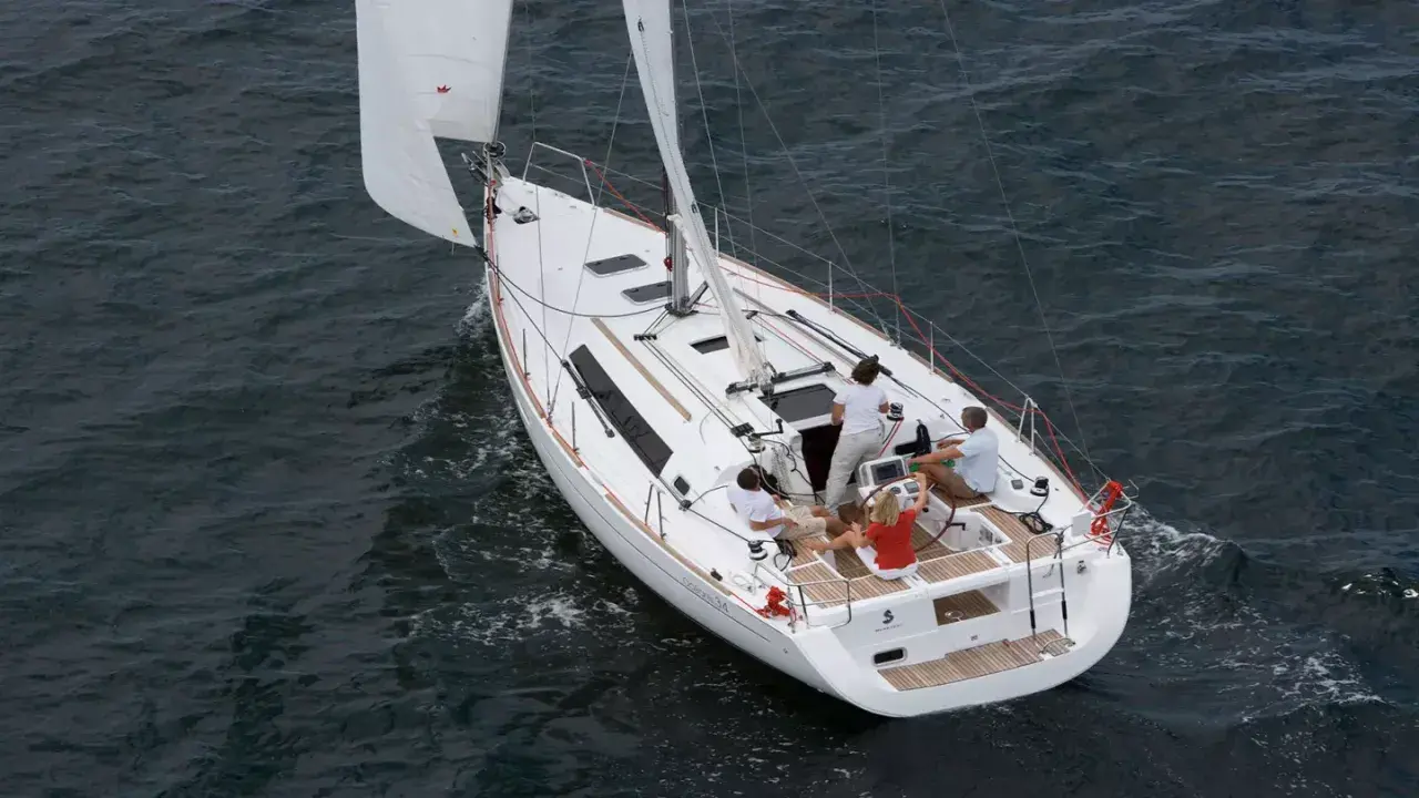 Un voilier Oceanis 34 navigue sur une mer agitée. Les avis sur ce bateau sont positifs, il offre une belle expérience de navigation.