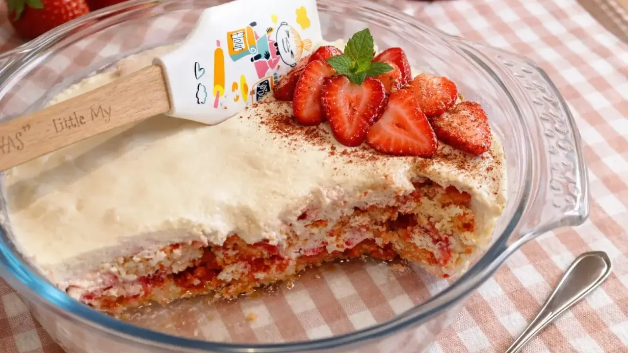 Un délicieux tiramisu fraise, garni de fruits frais et d'une touche de cacao, prêt à être dégusté.