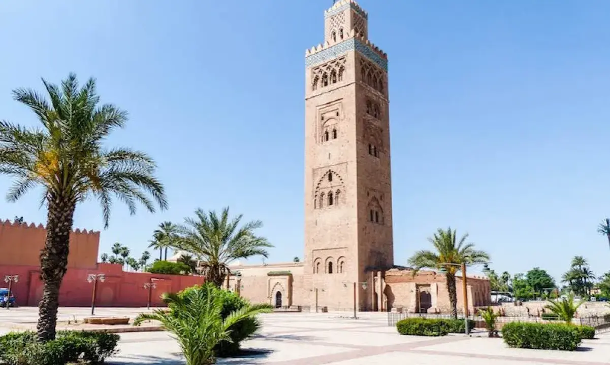 Koutoubia-Moschee in Marrakesch, ein Wahrzeichen und ein Muss für Marrakesch Geheimtipps. Palmen säumen den Platz.