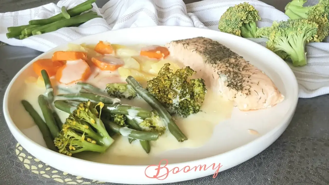 Filet de saumon avec un assortiment de légumes verts, carottes et pommes de terre en sauce crémeuse. Un plat savoureux et coloré.