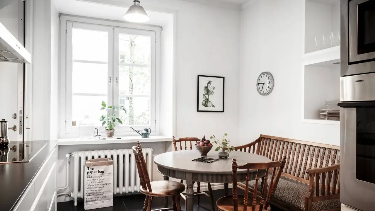 Mysig köksvrå med runt matbord, träbänk och stolar. Perfekt för runt matbord inspiration.