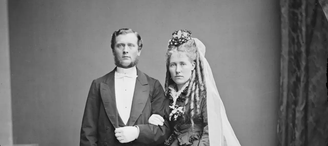 Brudpar i 1800-talets kläder, en viktig del av giftermål historia. Mannen bär frack, kvinnan slöja och blommor.