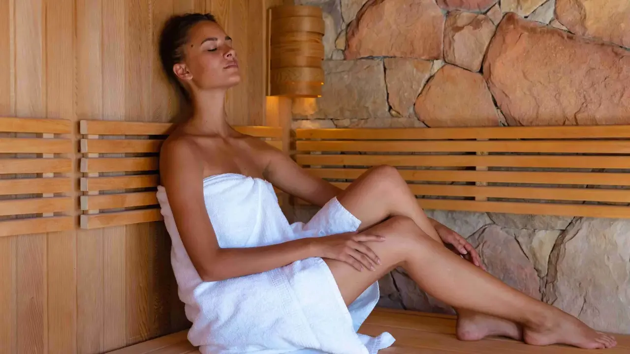 Kobieta w saunie, relaksująca się w ciszy. Zastanawiasz się, ile kcal spala sauna? To świetny sposób na odprężenie i wsparcie metabolizmu.