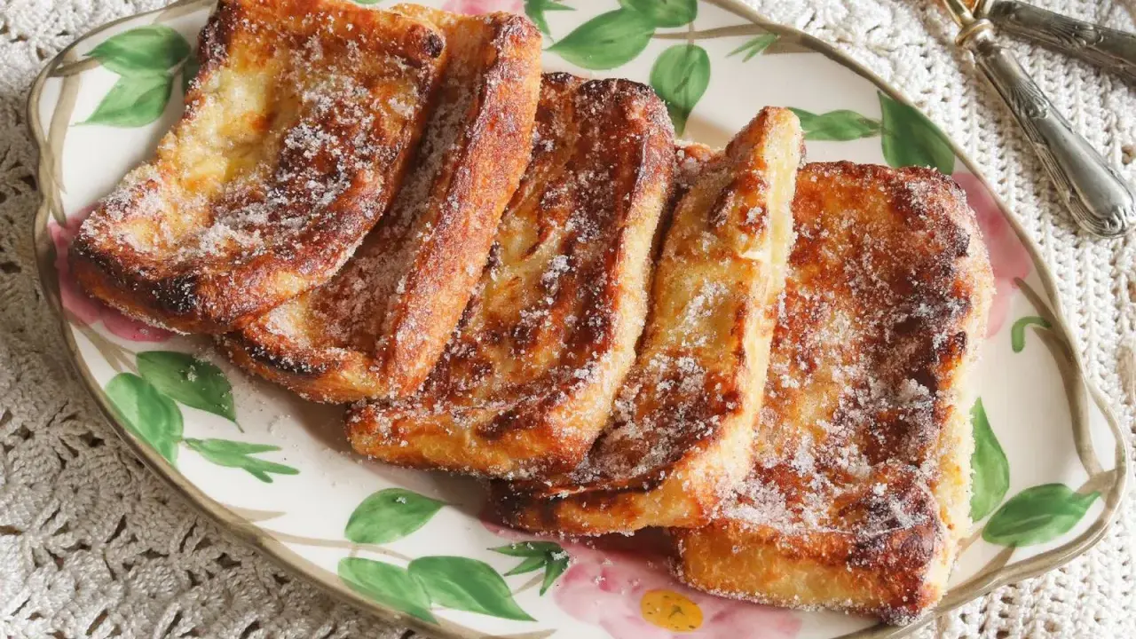 Torrijas doradas y crujientes, espolvoreadas con azúcar, listas para disfrutar. ¡Perfectas torrijas en freidora de aire!