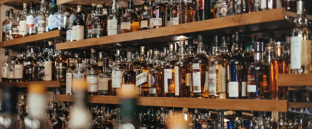 Regale voller Flaschen mit bernsteinfarbenem Whisky. Eine beeindruckende Auswahl für Kenner.