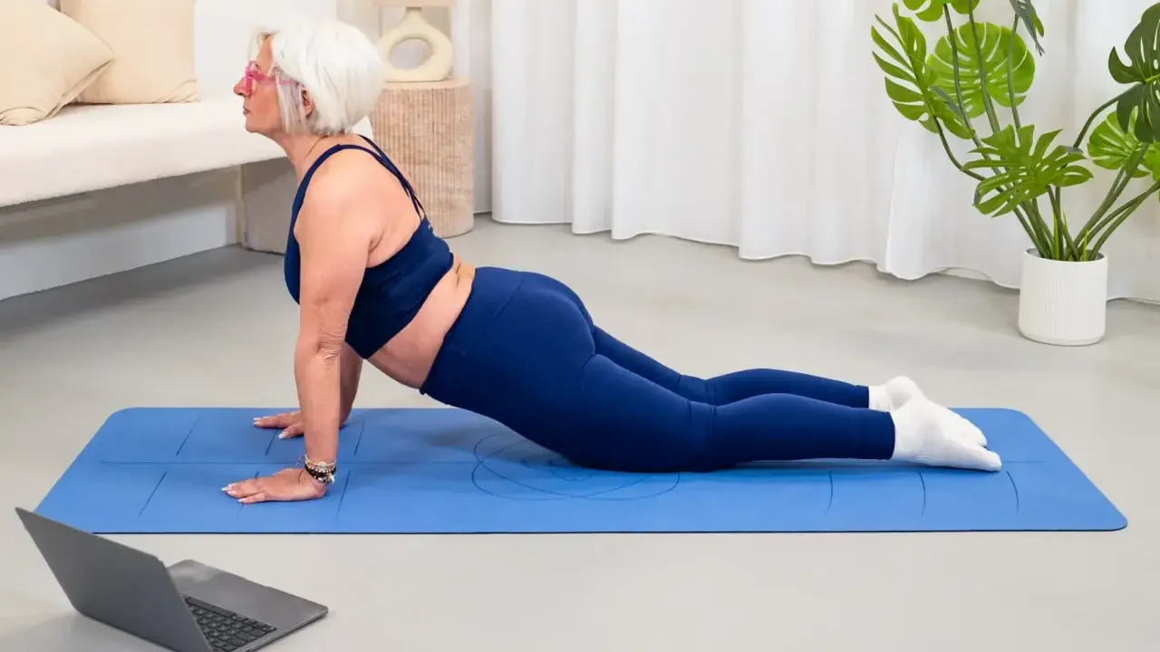 Donne di 50 anni in forma, praticano yoga a casa seguendo un tutorial online.