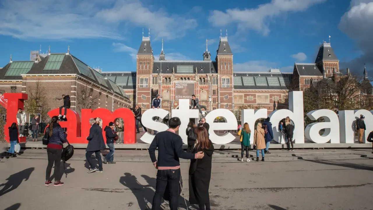 Ludzie pozują przy wielkich literach "I amsterdam" przed Rijksmuseum. Idealne miejsce na pamiątkowe zdjęcie z weekendu w Amsterdamie.