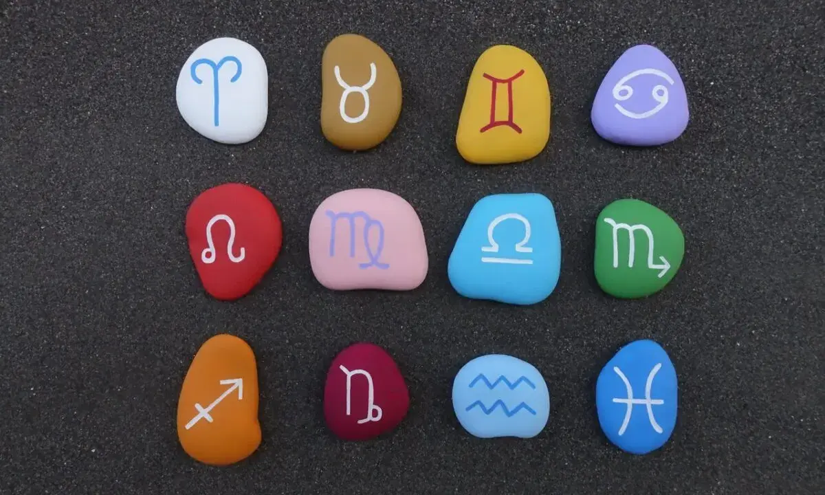 Kolorowe kamienie z symbolami zodiaku ułożone w rzędach. Sprawdź dopasowanie znaków zodiaku!