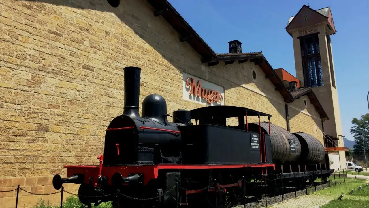 Locomotora antigua frente a las bodegas de Haro, transportando barriles de vino.