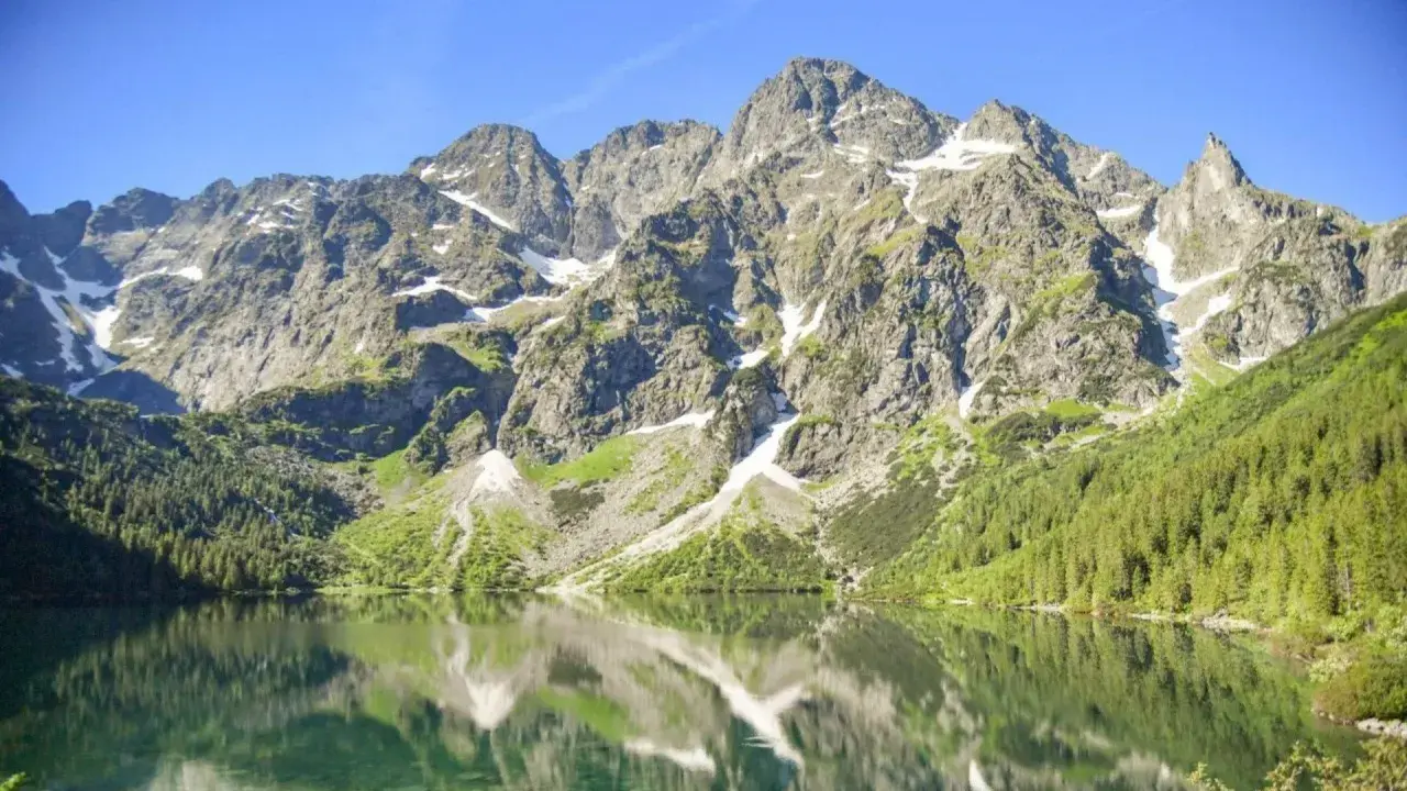 Górskie szczyty odbijają się w tafli Morskiego Oka. To jezioro znajduje się na wysokości 1395 m n.p.m.