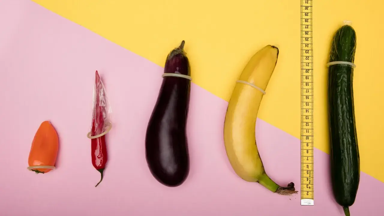 Pomarańczowa papryczka, czerwona papryczka chili, bakłażan, banan i ogórek, każdy w prezerwatywie, ułożone od najmniejszego do największego. Wygląda, jakby zmniejszył mi się członek.