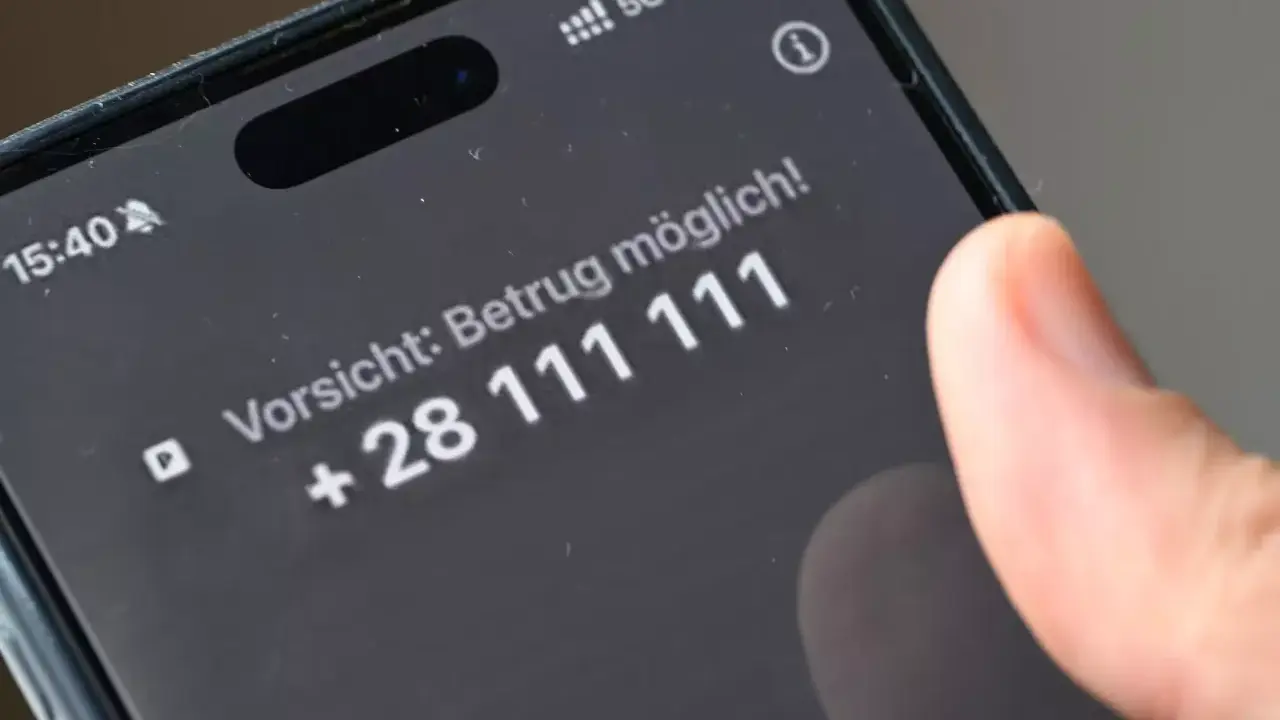 Vorsicht: Betrug möglich! Ein Finger tippt auf dem Smartphone, um Spam-Anrufe zu blockieren.