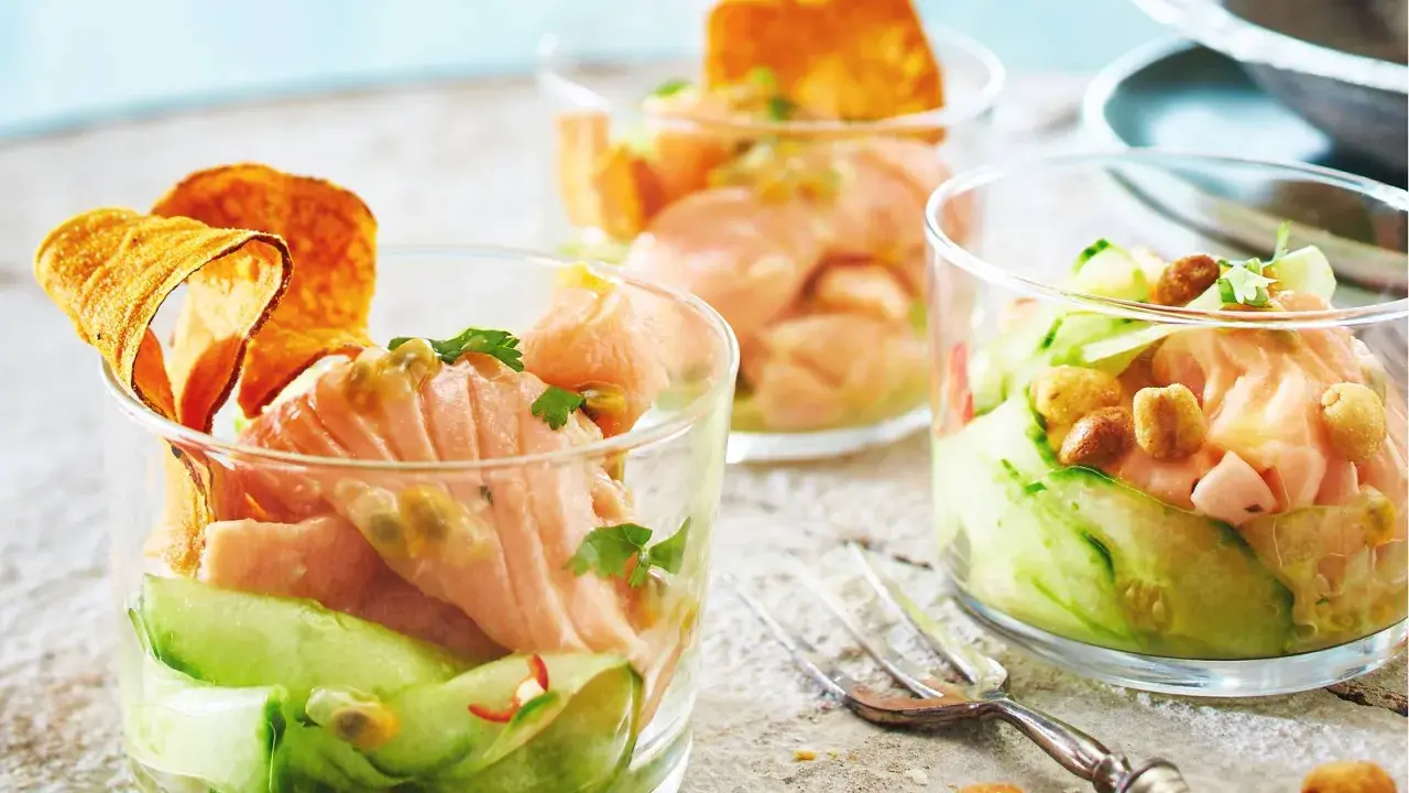 Drei Gläser mit raffinierten Vorspeisen zum Vorbereiten: Lachs-Tatar mit Gurke, Passionsfrucht und knusprigen Chips.