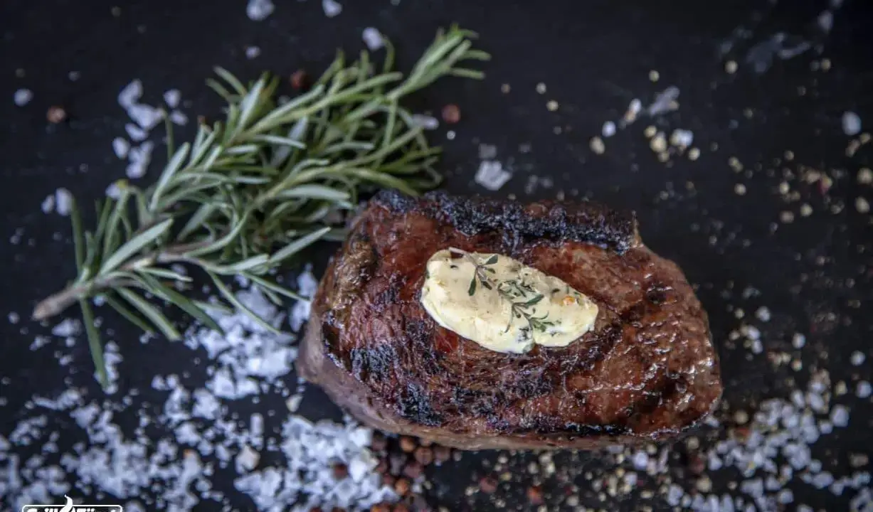 Perfekt medium gegrilltes Steak mit Kräuterbutter, Rosmarin und grobem Salz.