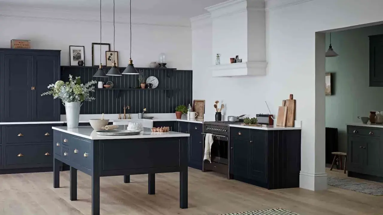 Elegancka kuchnia z ciemnogranatowymi, **czarnymi meblami kuchennymi**. Centralna wyspa i zabudowa tworzą spójną całość.