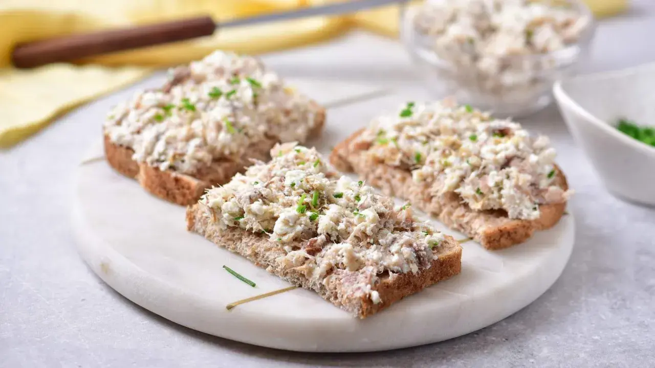 Pyszna pasta z makreli i twarogu na ciemnym pieczywie, posypana szczypiorkiem. Idealna na szybkie śniadanie lub przekąskę.