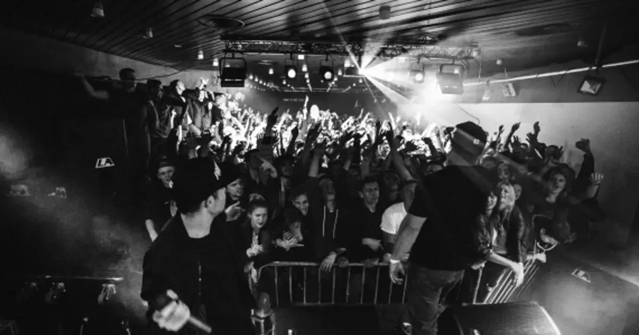 Koncert pro8l3m art brut 2 utwory. Tłum szaleje, artyści na scenie, światła i dym tworzą niepowtarzalny klimat.