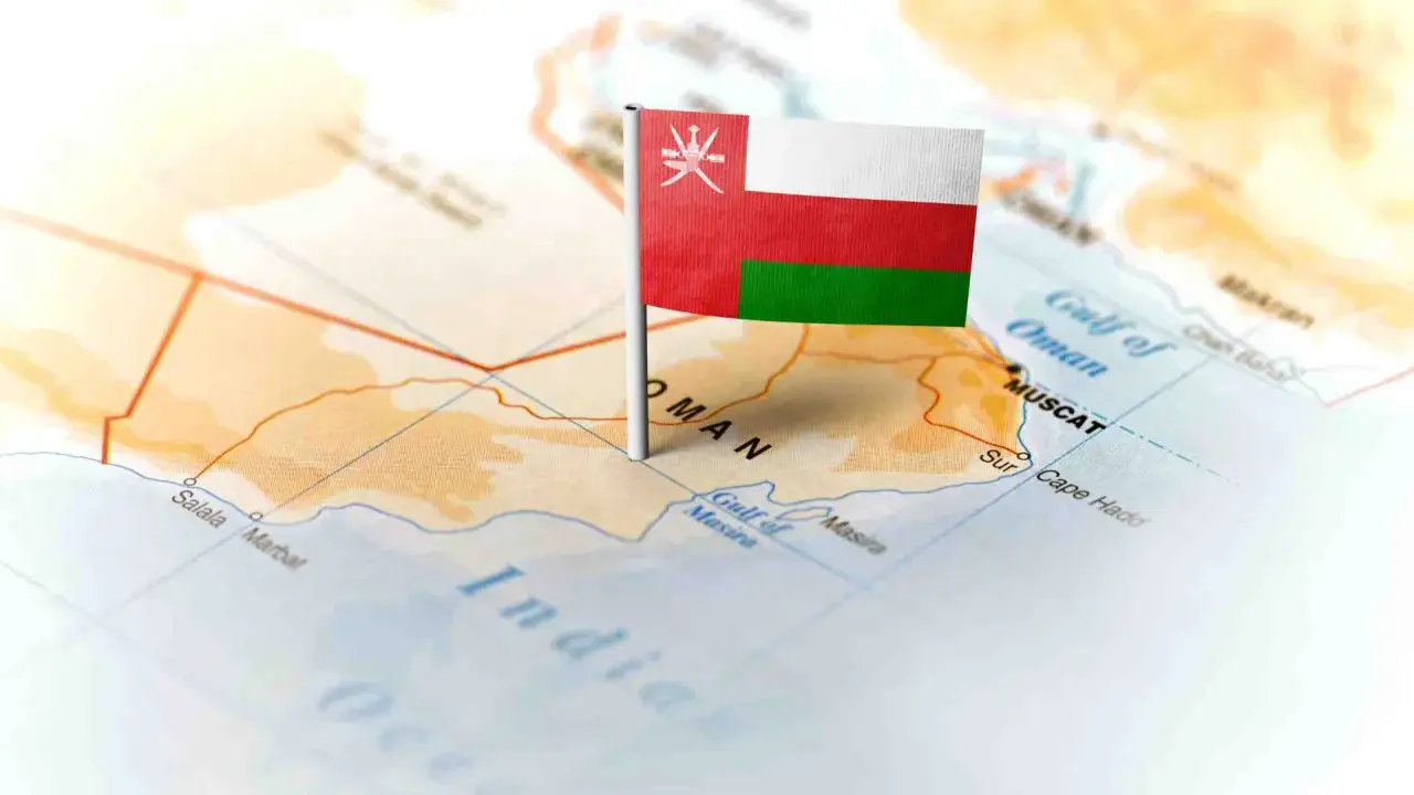 Flaga Omanu wbita w mapę, wskazująca gdzie leży Oman, nad Zatoką Omańską, w pobliżu Maskatu.